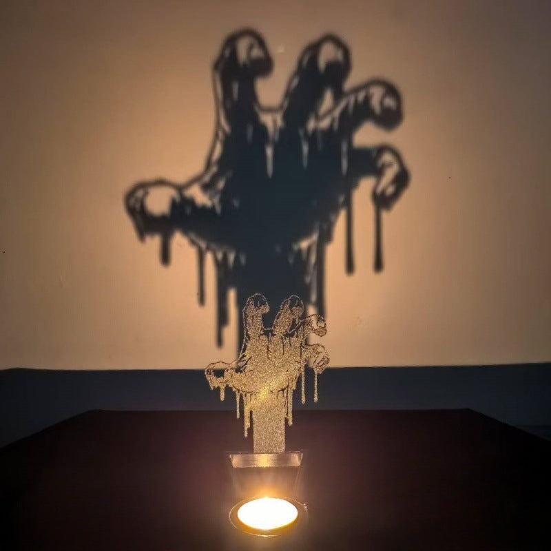 Zombie hand Halloween shadow candle holder projecting a large clawed palm silhouette on the wall
