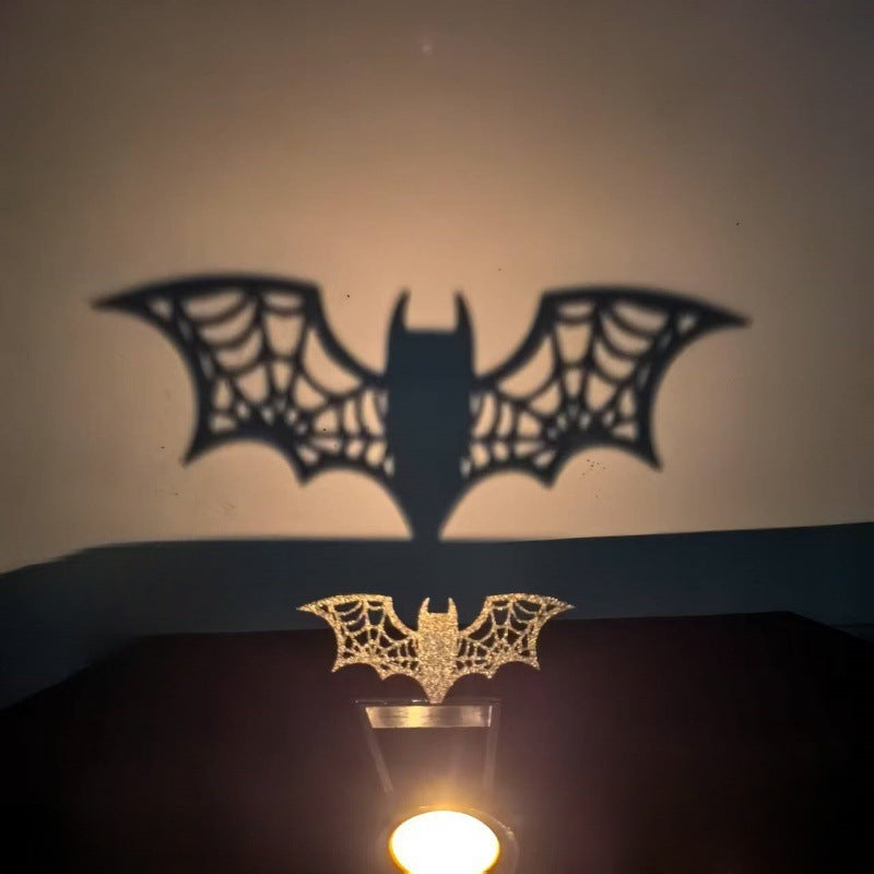 Bat Halloween shadow candle holder with spiderweb wings casting a wide bat shadow on the wall