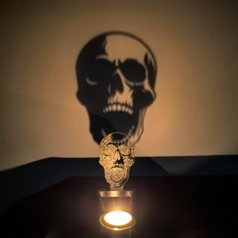 Skull Halloween shadow candle holder casting a detailed skull silhouette on the wall by candlelight