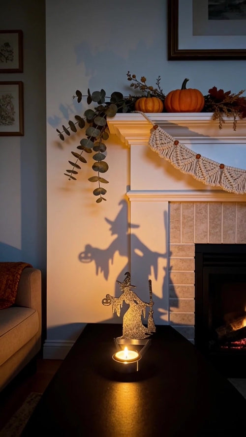 Halloween shadow candle holder on a mantel casting a giant witch silhouette across the living room wall